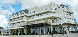 ein großes weißes Gebäude in einer Stadtstraße in der Unterkunft Hotel Carlito Tagaytay in Tagaytay