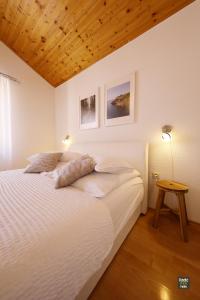 um quarto com uma cama branca e um tecto de madeira em Apartment Gordana em Vir