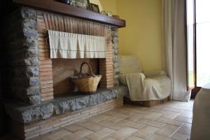 a living room with a brick fireplace with a chair at Fattoria Capobianco in Montefiascone