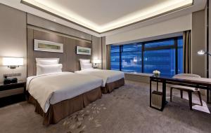 una camera d'albergo con due letti e una finestra di Pullman Shanghai Xuhui a Shanghai