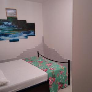ラ・カレッタにあるAppartamentino-La Calettaのベッドルーム1室(緑の毛布付きのベッド1台付)