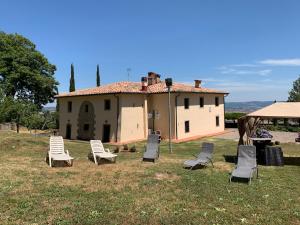 ピアンカスタニャーイオにあるPodere del Piccini con piscina in val d Orcia Toscanaの家前の芝生椅子群
