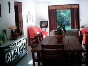 una sala da pranzo con tavolo, sedie e televisione di Casa Berlinque/ilha Itaparica a Vera Cruz Altre 22 foto