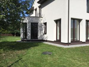 una casa blanca con un patio de césped en Radvi House en Druskininkai