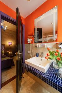 a bathroom with a white sink and an orange wall at Ad Place Venice in Venice
