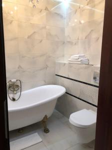 a white bathroom with a tub and a toilet at Dom Wiejska 39 a in Ruciane-Nida +58 photos