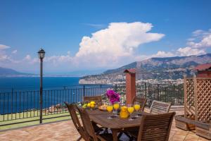 a wooden table on a balcony with a view of the ocean at Heart and Soul of Sorrento in Sorrento
