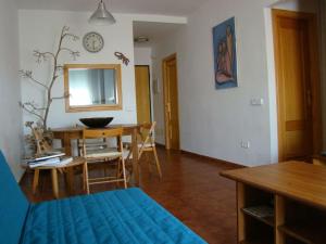 sala de estar con mesa y sofá azul en Nuestra casita en CABO DE GATA, en El Pozo de los Frailes