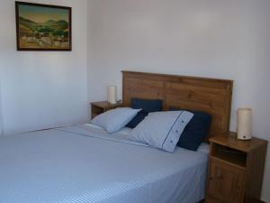1 dormitorio con 1 cama con sábanas azules y 2 velas en Nuestra casita en CABO DE GATA, en El Pozo de los Frailes