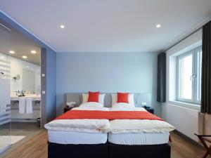 een slaapkamer met een groot bed met rode kussens bij Amel Mitte in Amel