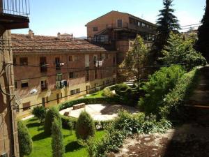 an old building with a garden in front of it at Hostal Residencia Taray in Segovia