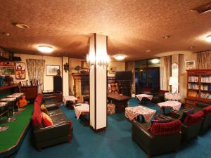 sala de estar con sofás, sillas y mesa en Hotel Mumon, en Myoko