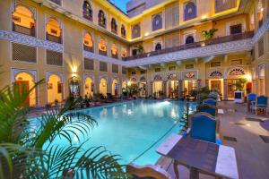 an indoor swimming pool in a building with a large building at Nirbana Palace - A Heritage Hotel and Spa in Jaipur