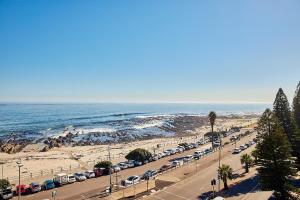 ein Parkplatz mit am Strand geparkt in der Unterkunft First Group Riviera Suites in Kapstadt