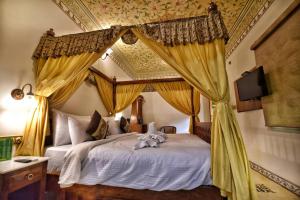 a large bed with a canopy over it at Nirbana Palace - A Heritage Hotel and Spa in Jaipur