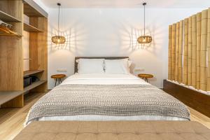 een slaapkamer met een groot bed en 2 tafels bij F & S LOUNGE SUITES in Parga