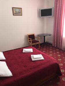 een hotelkamer met een rood bed en een tafel bij Коломия готель in Kolomiya