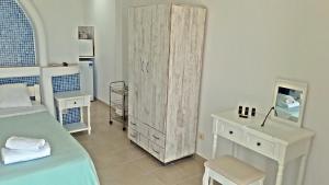 a bedroom with a bed and a dresser and a cabinet at Antoninis Village in Houlakia