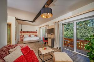 ein Wohnzimmer mit einem roten Sofa und ein Schlafzimmer in der Unterkunft Landhotel Moorhof in Neuschönau