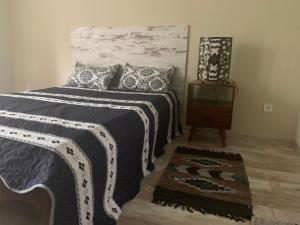 a bedroom with a bed with a black and white blanket at Villa Füred in Balatonalmádi