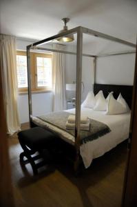 a bedroom with a canopy bed and a chair at Luxury Grimentz Apartment in Grimentz
