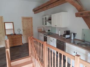 een keuken met witte kasten en een houten trap bij Ferienwohnung Havelblick in Ketzin