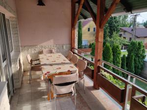 patio ze stołem i krzesłami na balkonie w obiekcie Vilma Villa w mieście Balatonmáriafürdő