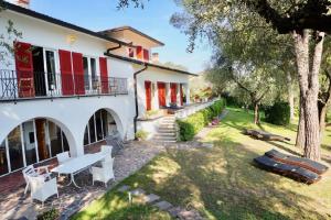 a house with red shutters and a patio at Gardavilla Limoni am See in Garda