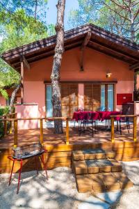 a house with a deck with a table and chairs at Camping Lacona Pineta in Capoliveri