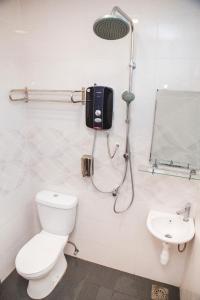 a bathroom with a shower and a toilet and a sink at Phoenix Hotel in Gua Musang