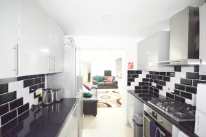 a kitchen with black and white tiles on the wall at London Zone 2 Three Bedroom Apartment in London