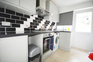 a kitchen with black and white tiles on the wall at London Zone 2 Three Bedroom Apartment in London