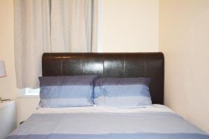 a bed with a leather headboard in a bedroom at London Zone 2 Three Bedroom Apartment in London