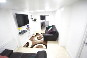 a living room with a couch and a flat screen tv at London Zone 2 Three Bedroom Apartment in London