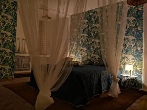 - une chambre avec un lit doté de rideaux et d'une lampe dans l'établissement ROOM33, à Viagrande