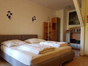 una camera da letto con un grande letto con lenzuola bianche di Gästewohnungen Hennig a Markkleeberg