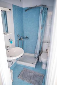 a bathroom with a tub and a sink and a toilet at Zoumboulis Rooms in Mytilini