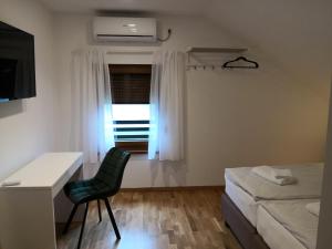 a bedroom with a desk and a chair and a window at Accommodation Plitvice in Korenica