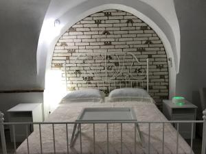 GrottoleにあるCasa vacanza kruptai 2019のレンガの壁のドミトリールームのベッド1台分です。