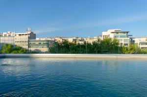 TURIM Boulevard Hotel في لشبونة: مجموعة كبيرة من المياه مع المباني في الخلفية