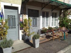 a porch of a house with a table and chairs at Le Piano in Biesles