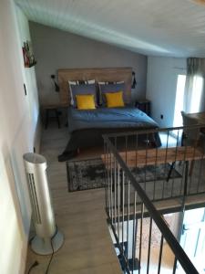 um quarto com uma cama com almofadas amarelas em La Petite Maison em Laroque-Timbaut