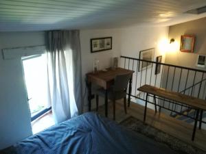 um quarto com uma secretária, uma cama e uma mesa em La Petite Maison em Laroque-Timbaut
