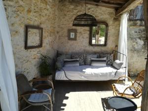 a bedroom with a bed in a stone wall at La Petite Maison in Laroque-Timbaut