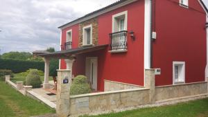 Casa roja con puerta y balcón en Pousada Carballo Blanco, en Barral