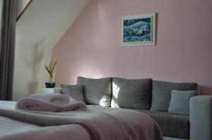 a living room with a couch and a pink wall at Motel Gombáš in Hubová