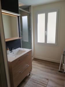 bagno con lavandino e specchio di L'Angély - Chambres d'Hôtes a Niort