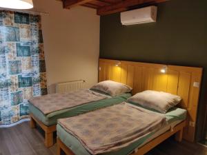 2 łóżka pojedyncze w pokoju ze ścianą w obiekcie Vilma Villa w mieście Balatonmáriafürdő