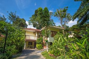 an exterior view of a house with trees at Krabi Green Hill Pool Villas in Ban Nong Thale