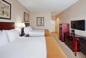 a hotel room with two beds and a flat screen tv at Holiday Inn Express Hotel & Suites Wichita Airport, an IHG Hotel in Wichita